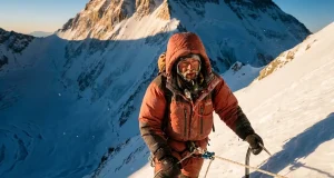 What an Everest Expedition Really Costs in 2026 Climber in a red down suit ascending a fixed line high on Everest at dawn on a 2026 expedition