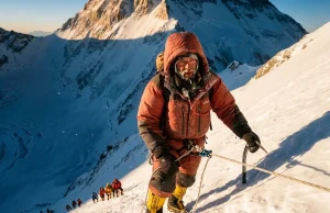 What an Everest Expedition Really Costs in 2026 Climber in a red down suit ascending a fixed line high on Everest at dawn on a 2026 expedition