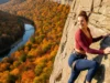 Gunks Climbing Guide: Pro Services & Guidebooks Compared A beautiful female climber with an athletic build smiling on a vast cliff face in the Gunks during autumn.