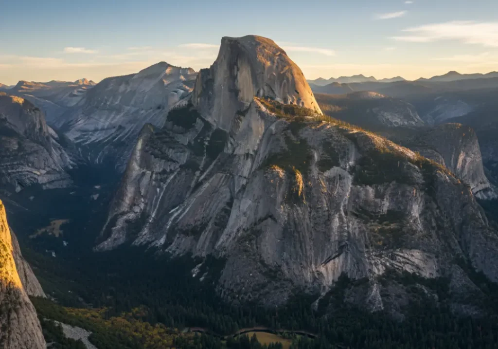 A wide, majestic photograph of the El Capitan rock formation in Yosemite, glowing in the light of the setting sun.