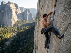 Alex Honnold Biography: A Climber’s Strategic Blueprint A climber free soloing a high granite wall with a valley floor far below.