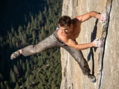 Alex Honnold Biography: A Climber’s Strategic Blueprint A climber free soloing a high granite wall with a valley floor far below.