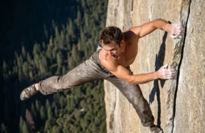 Alex Honnold Biography: A Climber’s Strategic Blueprint A climber free soloing a high granite wall with a valley floor far below.