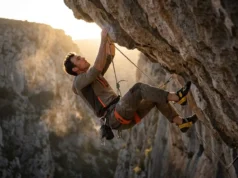 The Climber’s Post-Mortem: Learning From Every Mistake Climber hanging on a rope in a Black Diamond harness and La Sportiva shoes analyzing a climbing route after a fall.