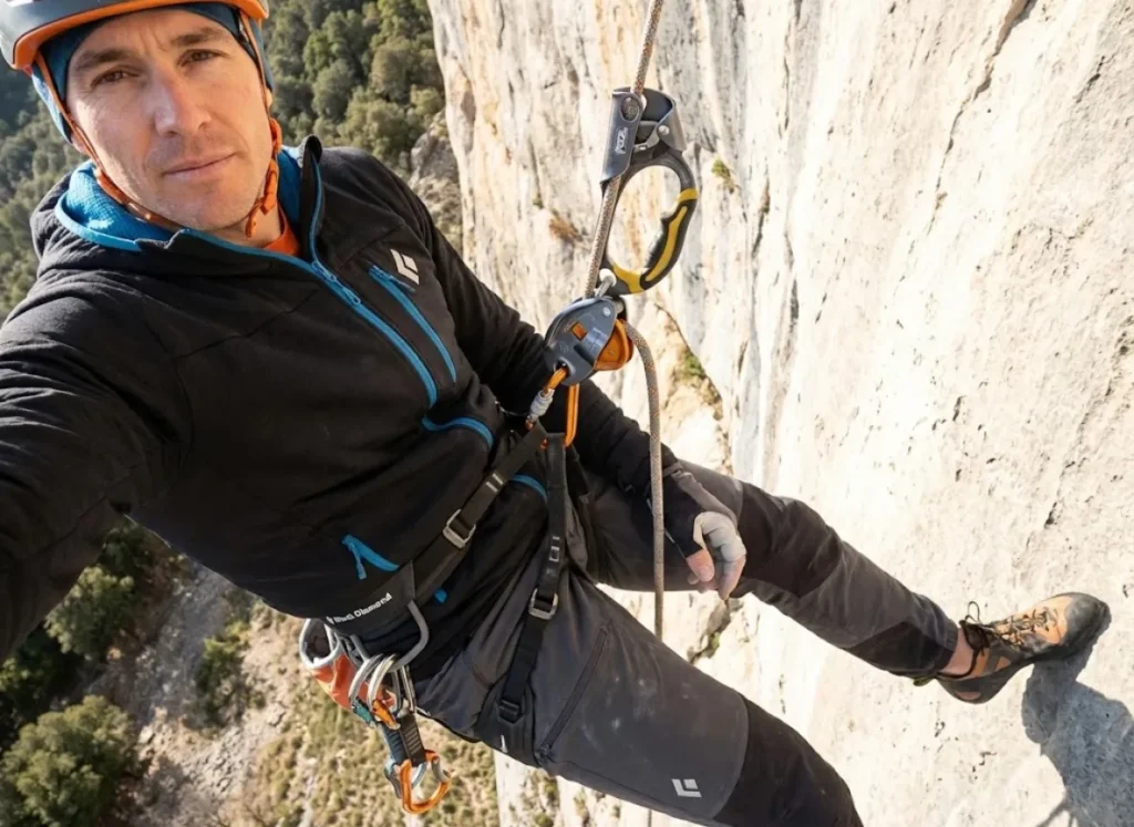 Climber using a Petzl Grigri and Ascension handle for a safe transition on a vertical wall.