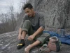 Velcro vs Lace vs Slipper Climbing Shoes by Discipline Climber lacing a La Sportiva Katana Lace shoe at the base of a gray granite crag