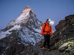 Climbing the Matterhorn: 2026 Routes & Prep Guide Alpinist wearing Mammut jacket and La Sportiva boots ascending the Hörnli Ridge at dawn with the Matterhorn summit towering above.