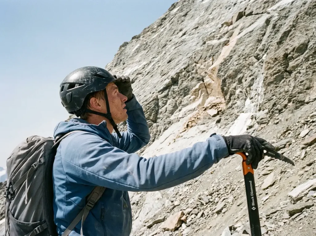 Climber assessing dry rockfall-prone rock on the Matterhorn ridge during a hot spell