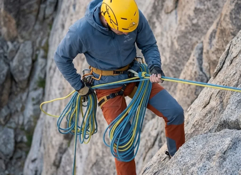 Climber rappelling with a Sterling rope saddlebagged on an Arc'teryx harness to prevent wind tangles.
