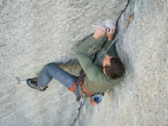 Use Alpine Draws To Reduce Rope Drag Friction Climber on a granite corner route using an alpine draw to straighten the rope path, wearing Arc'teryx gear and using a Mammut rope.