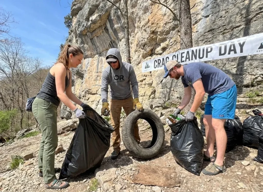 Volunteer climbers participating in crag cleanup day collecting trash to preserve access