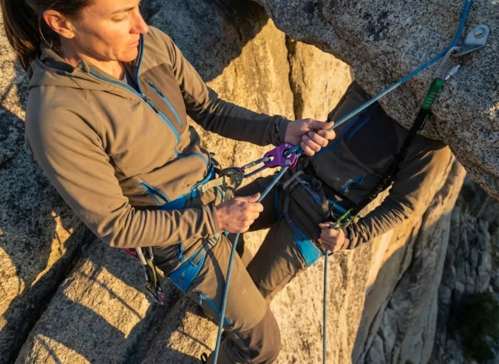 Climber weight-testing autoblock friction hitch while anchored before rappel