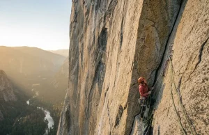Hiring a Guide for The Nose on El Capitan: Is $6,000 Worth It? Climber high on El Capitan's Nose route at golden hour with Yosemite Valley hazy far below