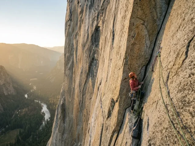 hero-the-nose-el-capitan-guided Climber high on El Capitan's Nose route at golden hour with Yosemite Valley hazy far below