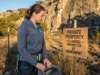 Climbing on Private Land? Liability Laws Every Climber Must Know Climber reviewing private land climbing access sign at crag entrance on Texas ranch property