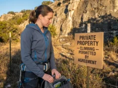 Climbing on Private Land? Liability Laws Every Climber Must Know Climber reviewing private land climbing access sign at crag entrance on Texas ranch property