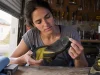 How to Resole Climbing Shoes So They Don’t Peel Worn climbing shoe held sole-up on a workbench before a resole, toe rubber thinned through