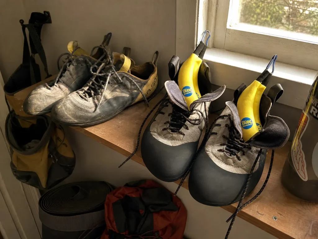 Climbing shoes drying on a shelf with deodorizers inside after a session to extend time between resoles