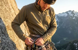 Best Alpine Climbing Harness? What 200 Pitches Taught Us Climber organizing gear on alpine harness at hanging belay on granite multi-pitch route