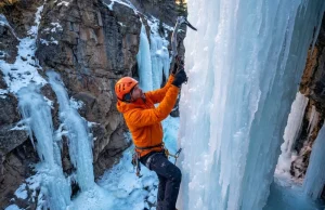 Best Crampons for Ice Climbing? What 200 Pitches Taught Us Ice climber ascending frozen waterfall with Petzl Lynx crampons on steep blue ice in Ouray Colorado