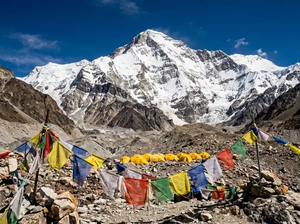 Cho Oyu's turquoise-tinged summit pyramid above Tibetan base camp prayer flags under hard noon light