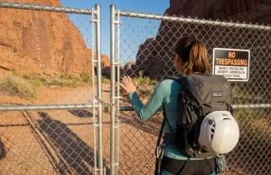 How to Report Climbing Access Issues Before It’s Too Late Climber faces locked gate blocking access to a desert crag approach trail