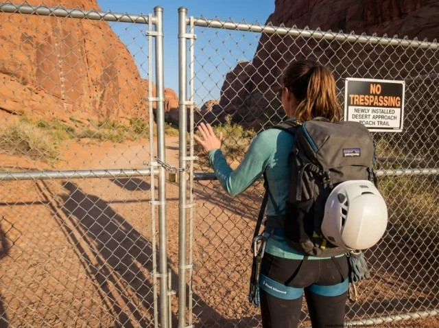 climbing-access-issue-locked-gate-approach Climber faces locked gate blocking access to a desert crag approach trail