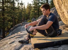 Rolled Your Ankle Climbing? The Field Fix That Works Climber removing La Sportiva shoe after ankle injury at granite bouldering crag, first aid protocol