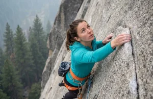 Your Climbing Photos Suck Because You Shoot From Below Climber on steep granite wall captured from above showing full body, face, and dynamic reach — climbing photography tips