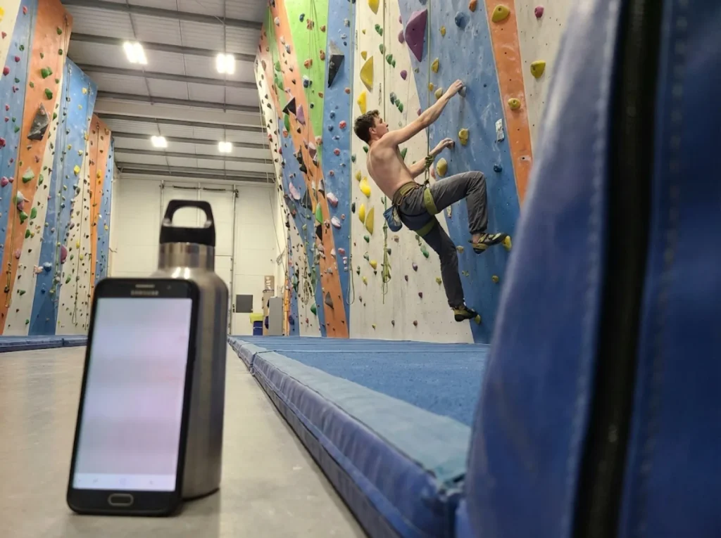 Climber filming themselves discreetly without blocking gym walkways or mats