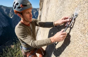 They Almost Banned Every Fixed Anchor in America Climber clipping a fixed bolt on a granite wilderness wall — fixed anchor policy climbing guide