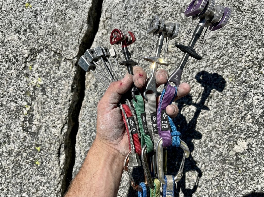 Close-up of a clean trad rack of nuts and cams for anchor-free wilderness climbing