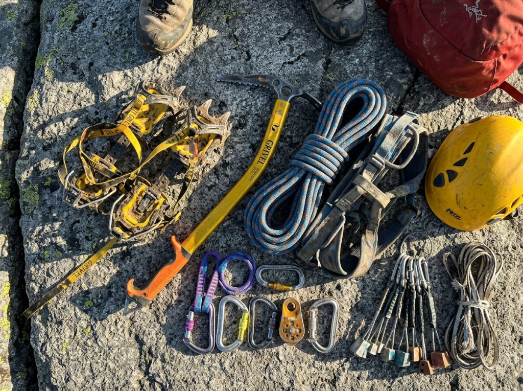 Glacier and alpine climbing kit laid out on rock before a North Cascades climb