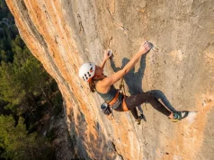 How to Project a Sport Route Without Wasting Burns Climber projecting a sport route reaches for a crimp on steep limestone