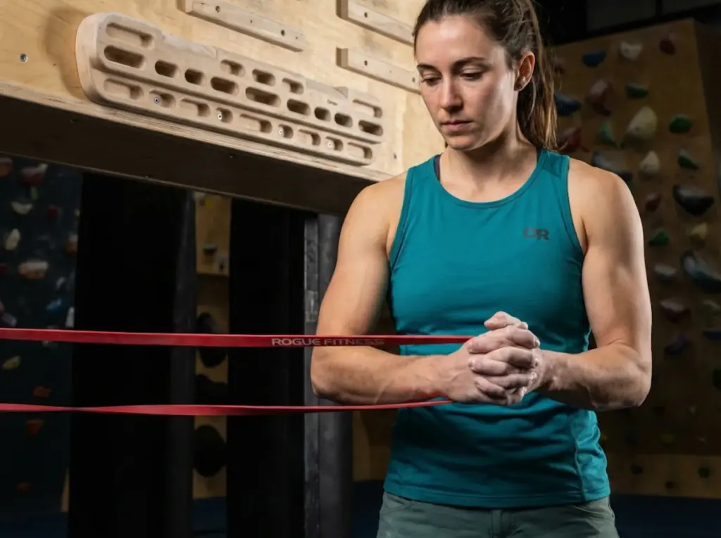Climber using resistance band for shoulder rotation in periodized training program