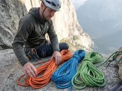 Rope Diameter Selection Guide (From a Gear-Obsessed Climber) Climber comparing three climbing ropes of different diameters on a granite ledge