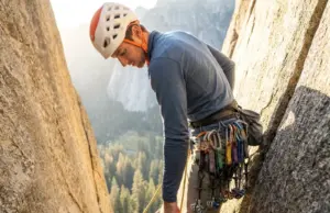 I Tested 3 Rack Systems for 6 Months on Real Routes Climber reaching for cam on organized harness rack during multi-pitch crack climb