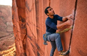 Best Crack Climbing Shoes That Won’t Wreck Your Feet climber jamming La Sportiva TC Pro crack climbing shoes into Indian Creek splitter crack at golden hour