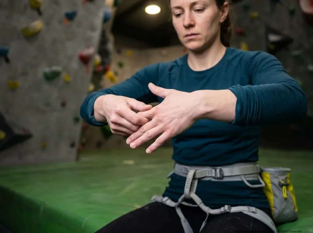 Climber performing finger pulley self-assessment after 4x4 training, pressing A2 zone to check for strain