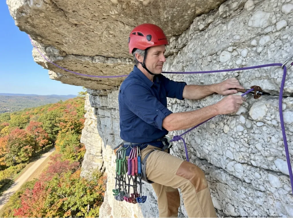 Experienced climber traversing beneath a massive roof on Shawangunk conglomerate at the Gunks in New York 