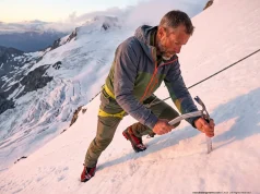 How to Build a Snow Anchor That Won’t Rip Out Mountaineer driving Black Diamond snow picket into glacier slope for crevasse rescue anchor