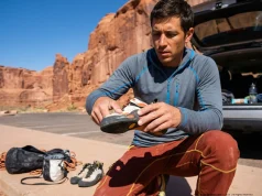 How to Fix Delaminating Climbing Shoes for Good Climber inspecting delaminating toe rand on La Sportiva Solution at desert crag