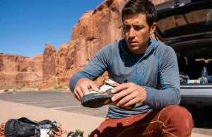 How to Fix Delaminating Climbing Shoes for Good Climber inspecting delaminating toe rand on La Sportiva Solution at desert crag