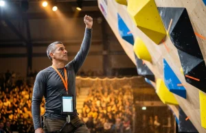 How to Judge a Climbing Competition Scoring System Competition climbing judge raises hand to confirm a Top score at IFSC-style bouldering event