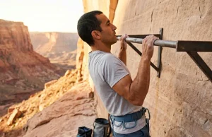 How to Bulletproof Your Climbing Shoulders for Good Climber performing scapular pull-up on outdoor training wall for shoulder injury prevention