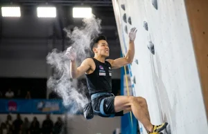 Speed Climbing Technique Explained With Physics Speed climber mid-dyno on IFSC standardized wall wearing La Sportiva Cobra 4.99 slippers during competition