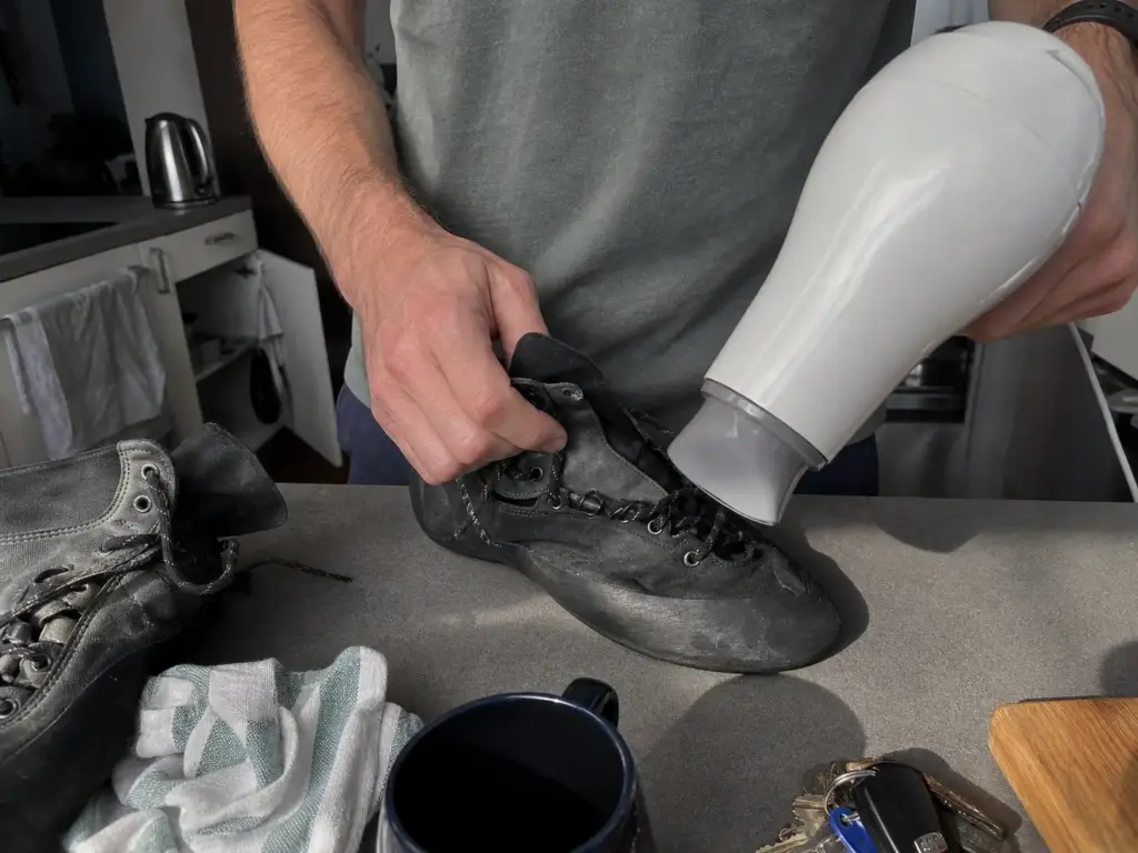 Warming a climbing shoe with a hair dryer to soften the upper safely during break in