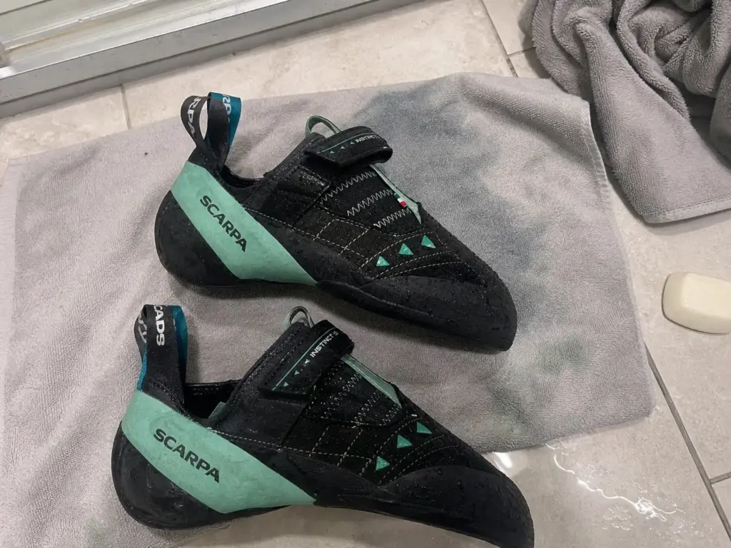 Wet climbing shoes on a towel after a hot water soak showing dye bleed onto the fabric