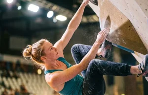 7 Best Climbing Documentaries About Competitions Ranked Female competition climber executing a difficult bat-hang move on fiberglass volumes