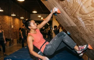 Climbing Gyms in LA That Are Actually Worth It Climber on bouldering wall at Los Angeles climbing gym with chalk-dusted hands reaching for hold